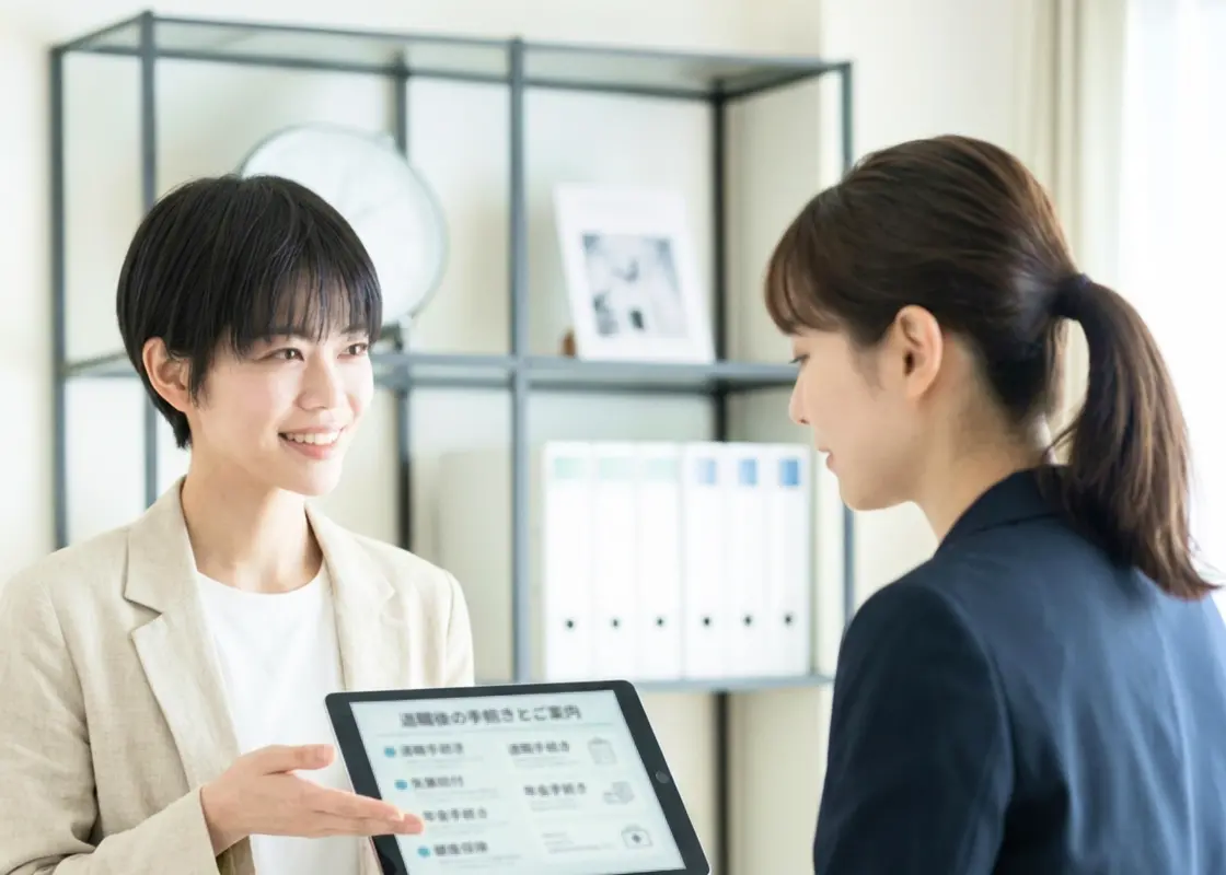 相談員がタブレットで退職後の手続きを案内している様子